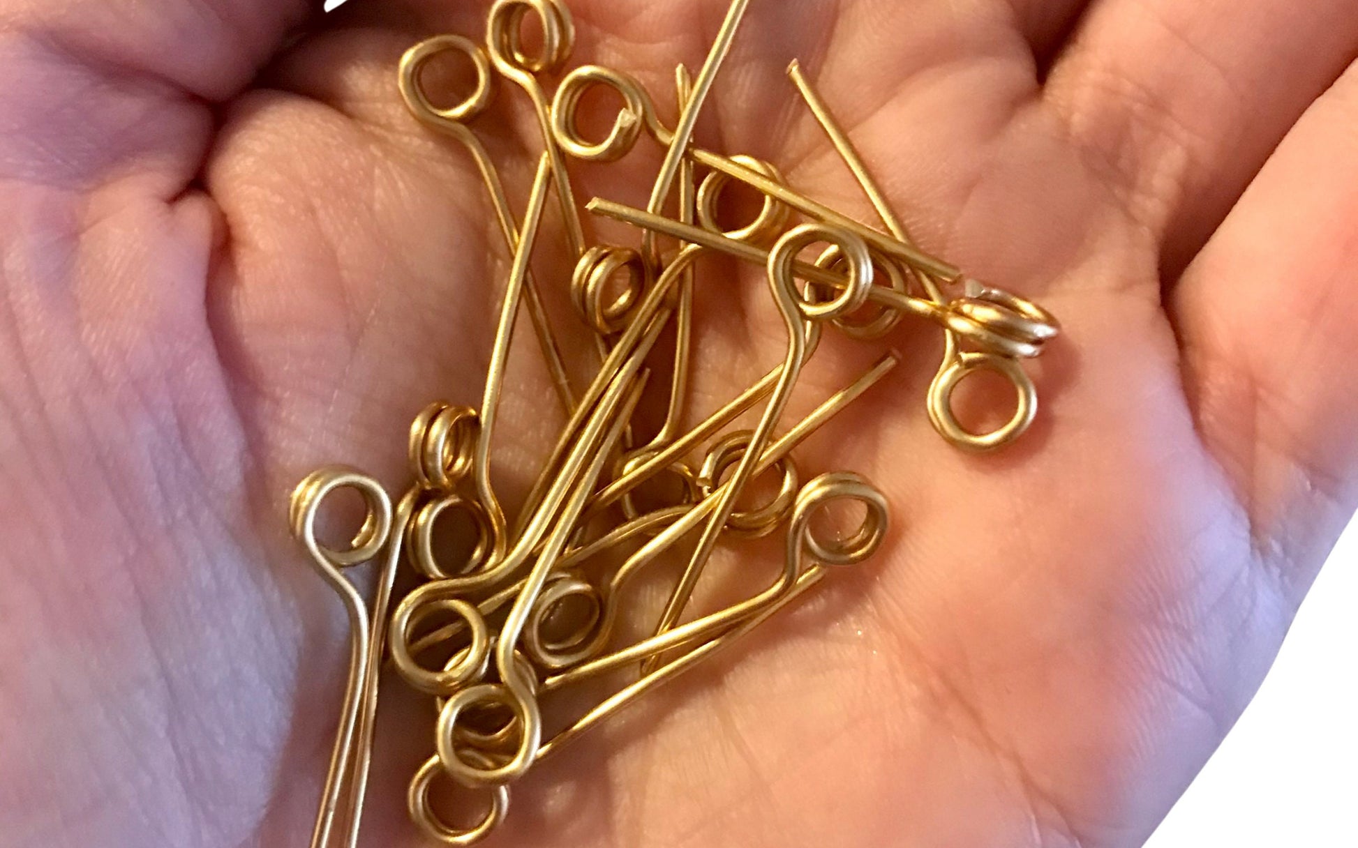 Close-up of mini round gold wire place card clips being held by a hand