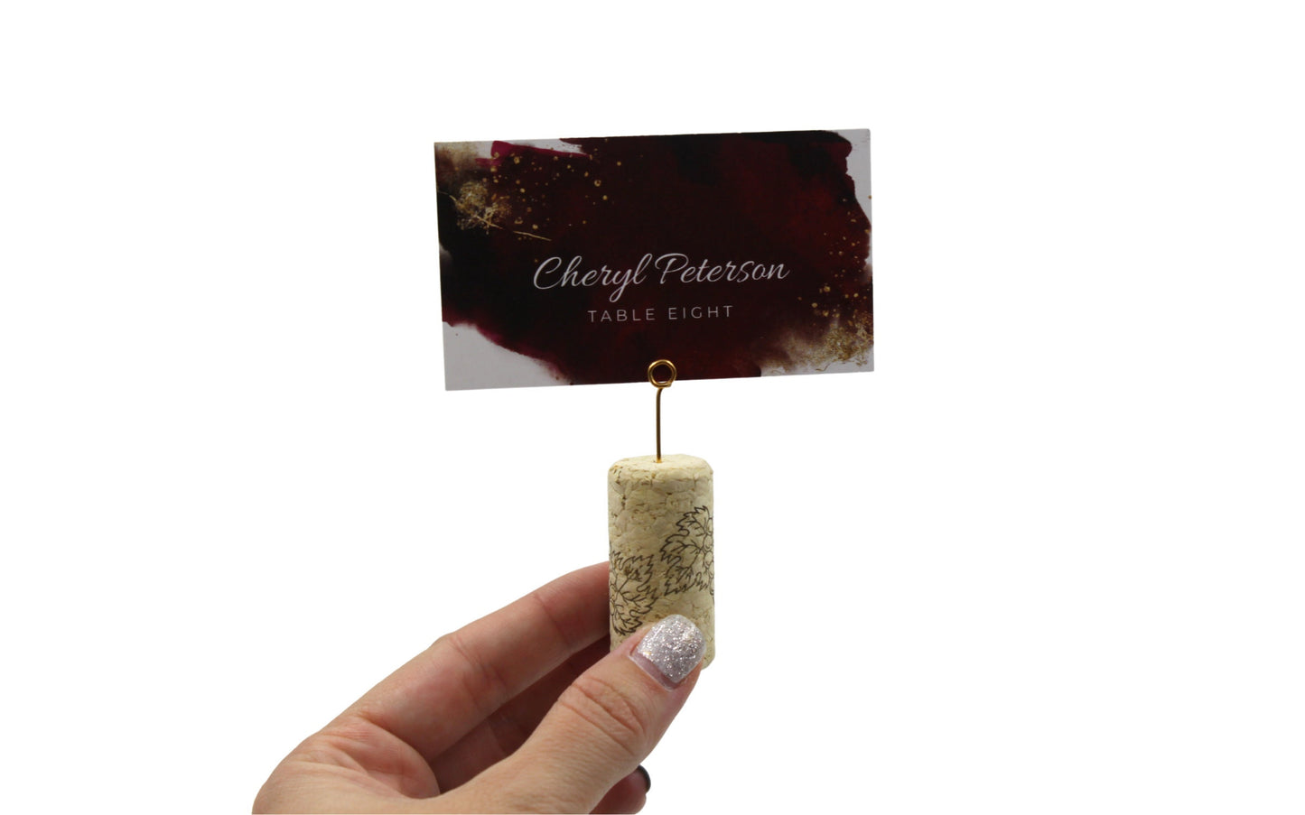 Close-up of mini round gold wire place card clip being held by a hand