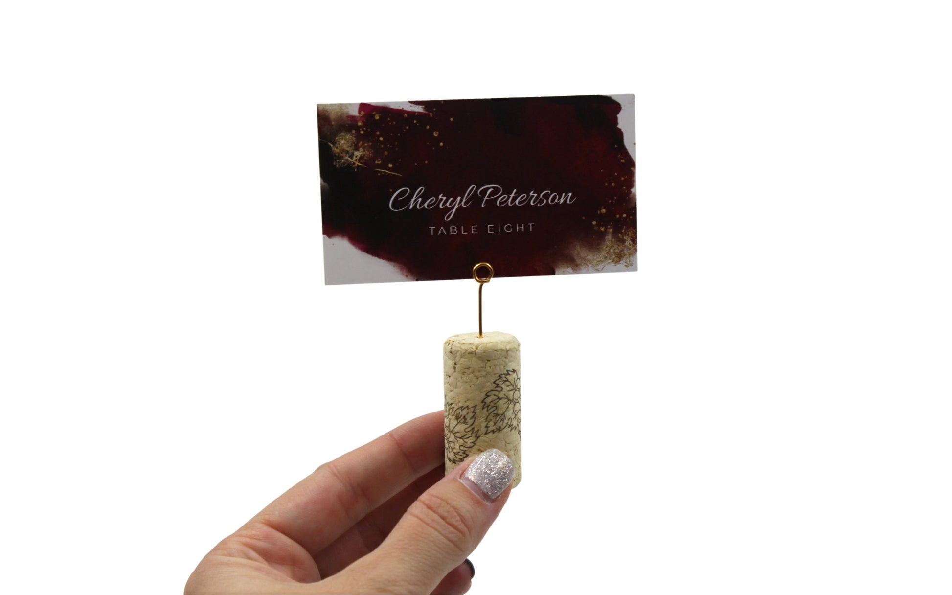 Close-up of mini round gold wire place card clip being held by a hand