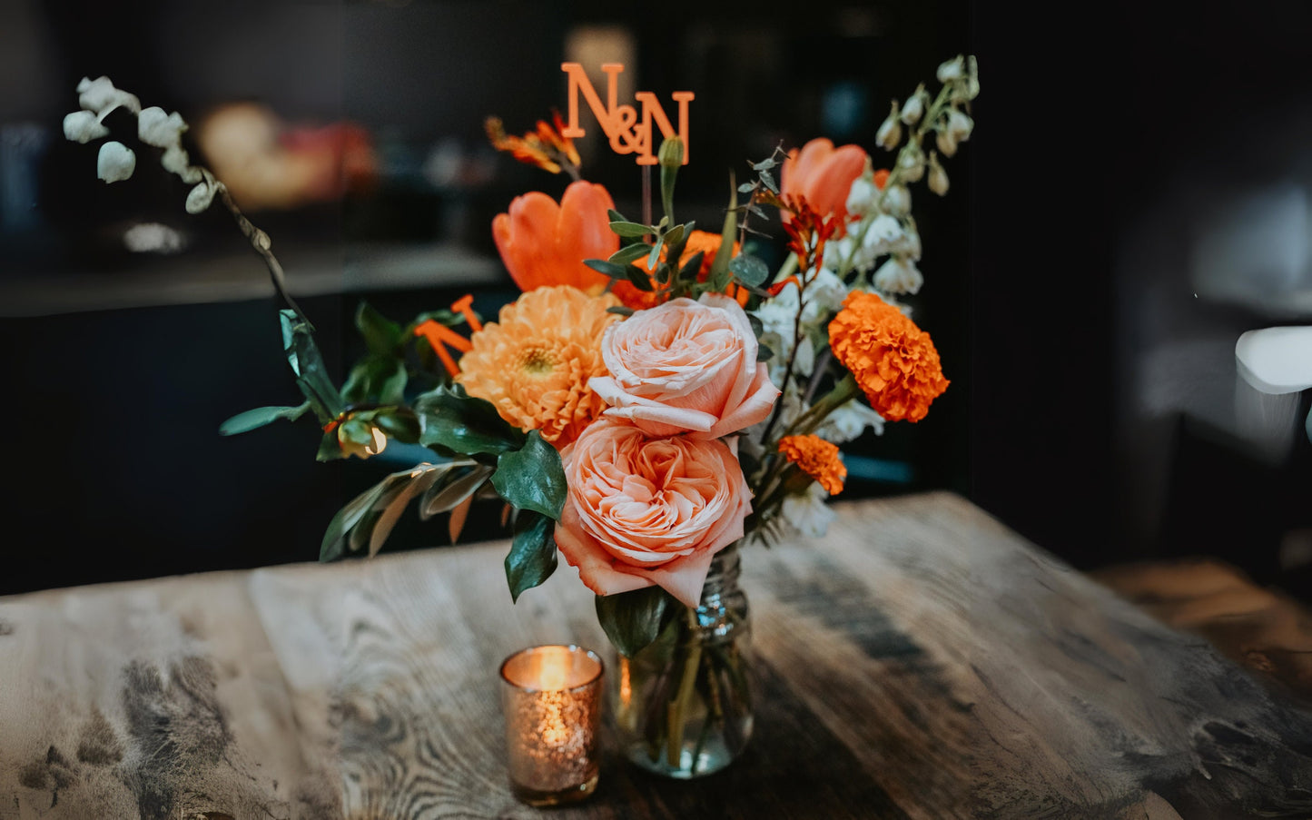 Custom name and initial sticks used in floral wedding centerpiece